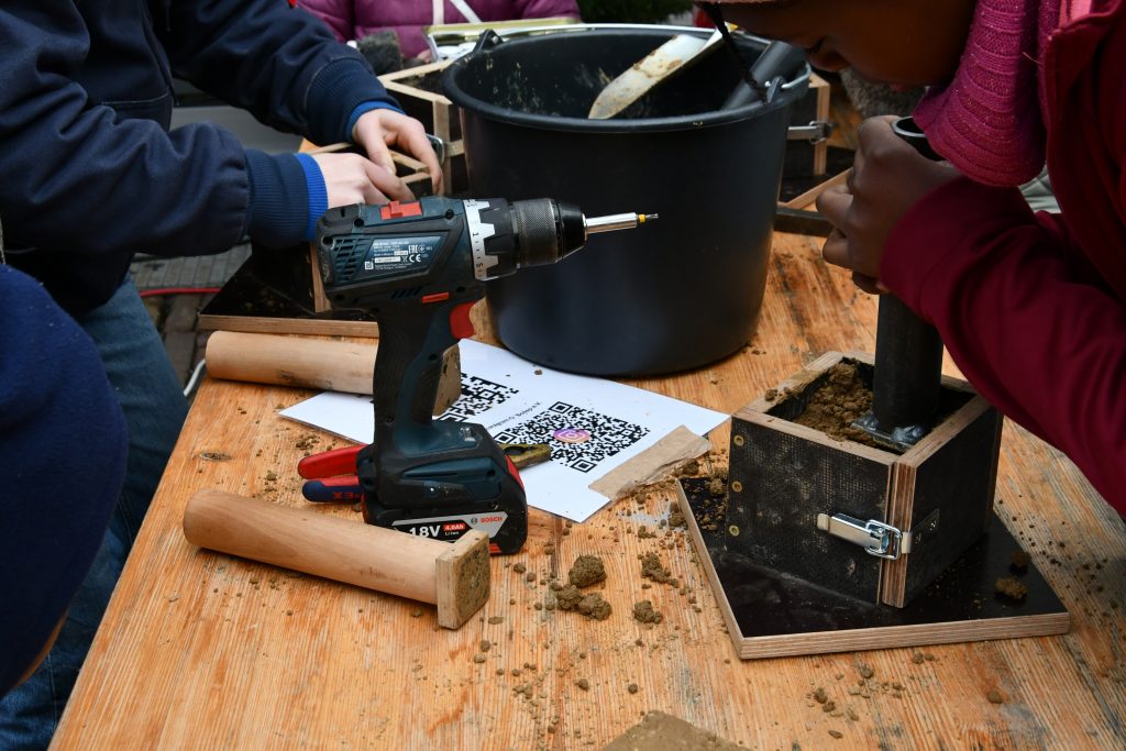 Bau von Teelichthaltern aus Stampflehm auf dem Nikolausmarkt